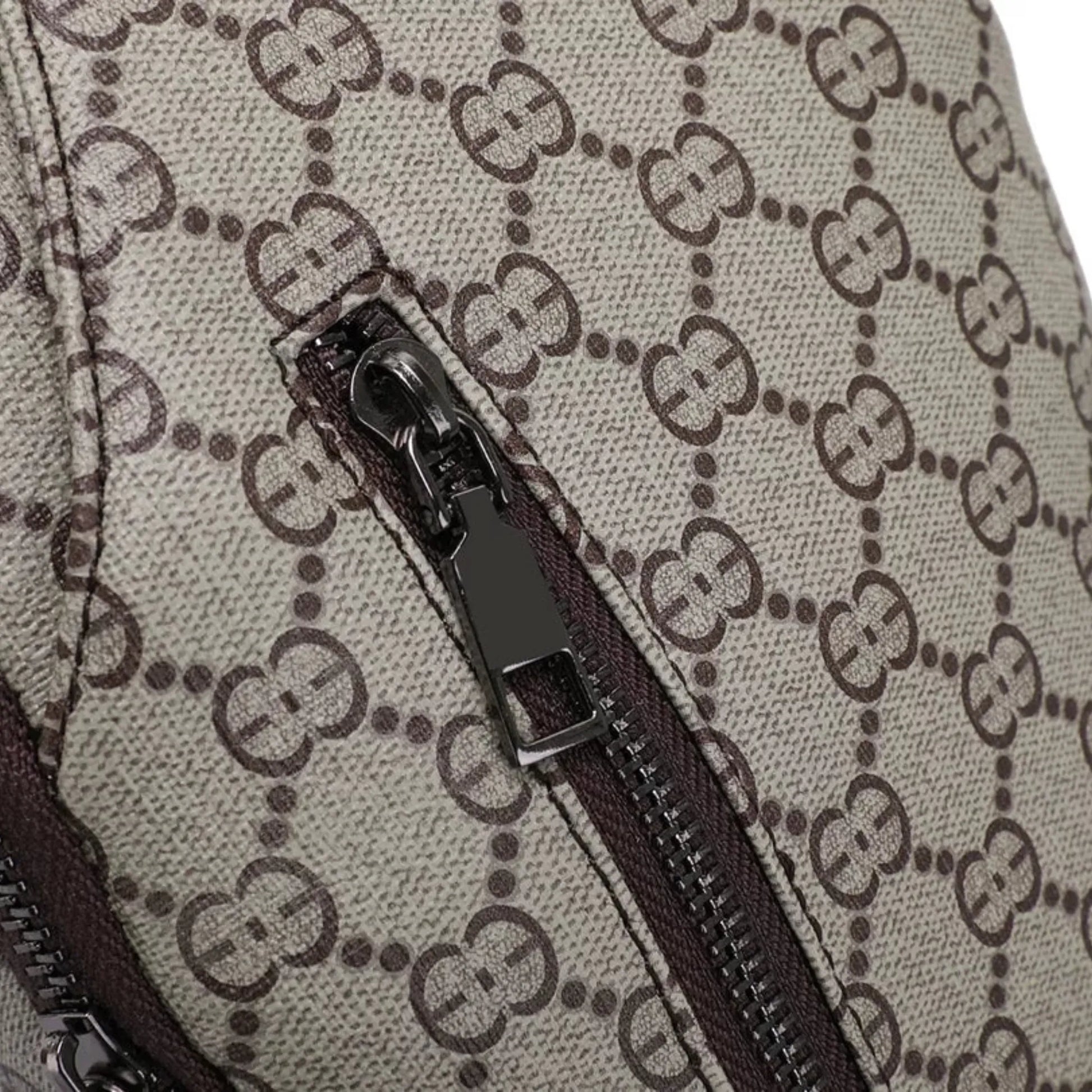 Close-up of a zipper on a Gucci bag with monogram pattern