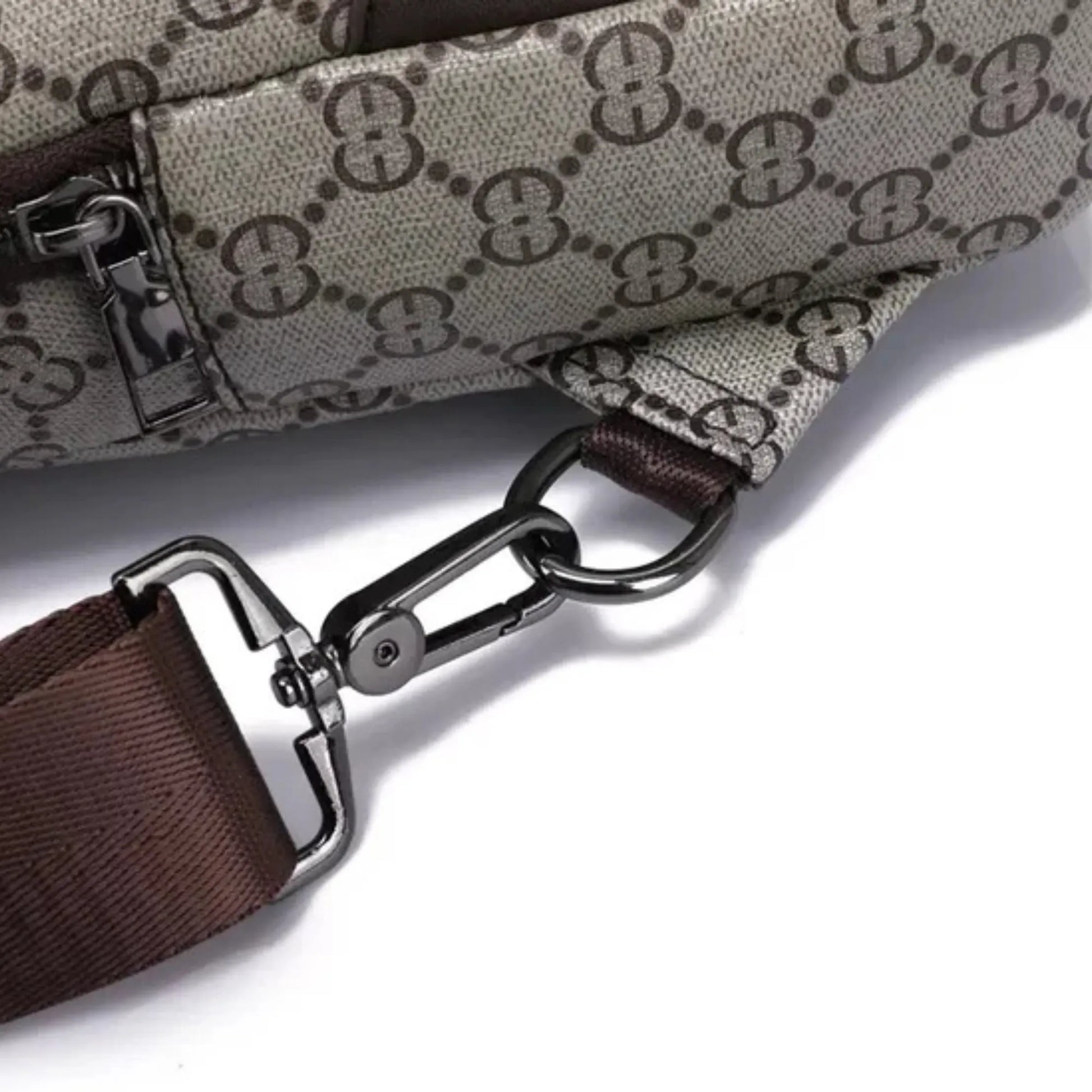 Close-up of a patterned bag with a brown strap and silver buckle on a white background